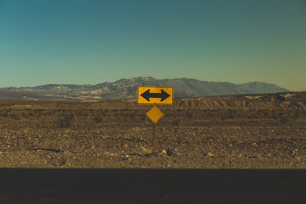 A sign near in a fork in the road.