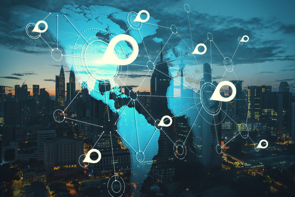 International geolocation concept with digital world map and white pinpoints connected by lines on night city skyscrapers background. Double exposure